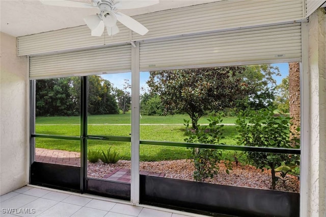 doorway to outside with ceiling fan and light tile patterned flooring