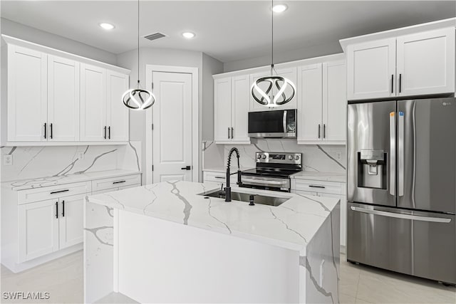 kitchen featuring white cabinetry, stainless steel appliances, a center island with sink, and hanging light fixtures