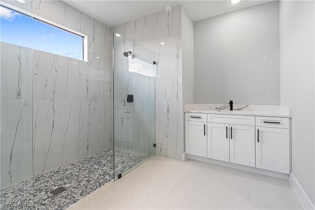 bathroom with vanity, tiled shower, and tile patterned flooring