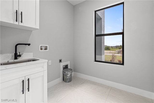 laundry area with cabinets, washer hookup, light tile patterned flooring, electric dryer hookup, and sink