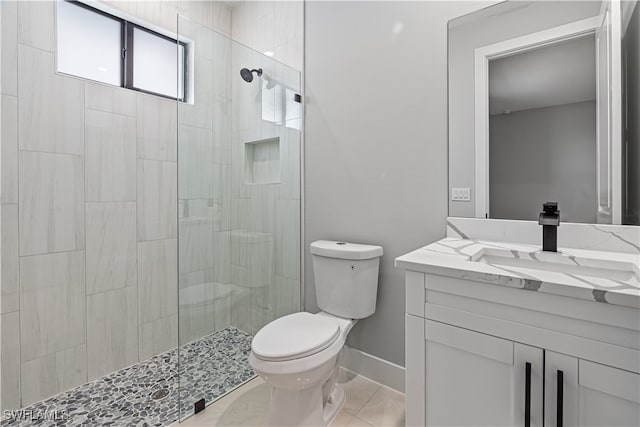 bathroom featuring toilet, an enclosed shower, vanity, and tile patterned floors