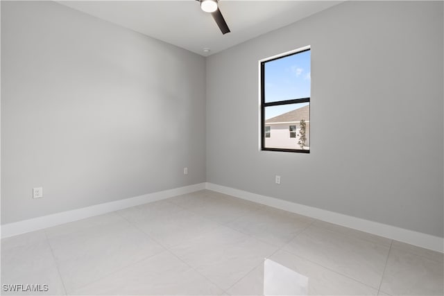 tiled spare room featuring ceiling fan