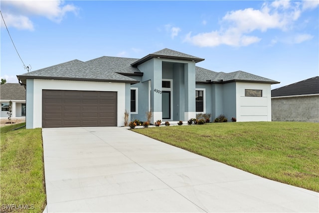 prairie-style home with a front lawn and a garage