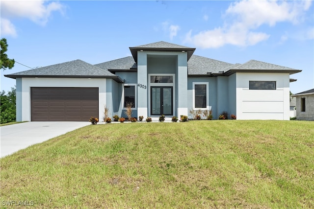 prairie-style house featuring a front yard and a garage