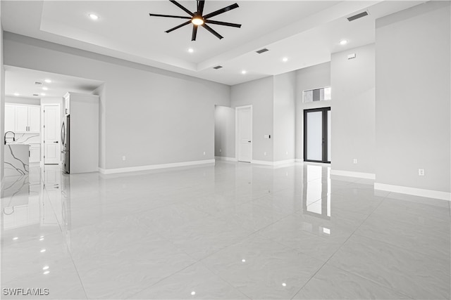 spare room with a raised ceiling, a towering ceiling, and ceiling fan