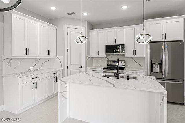 kitchen featuring a center island with sink, appliances with stainless steel finishes, and white cabinets