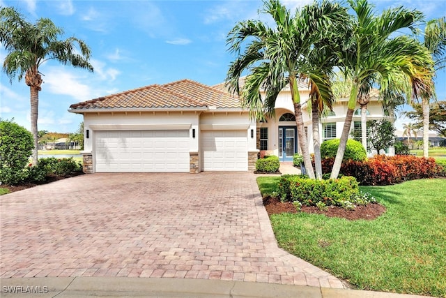 mediterranean / spanish-style house with a front yard and a garage