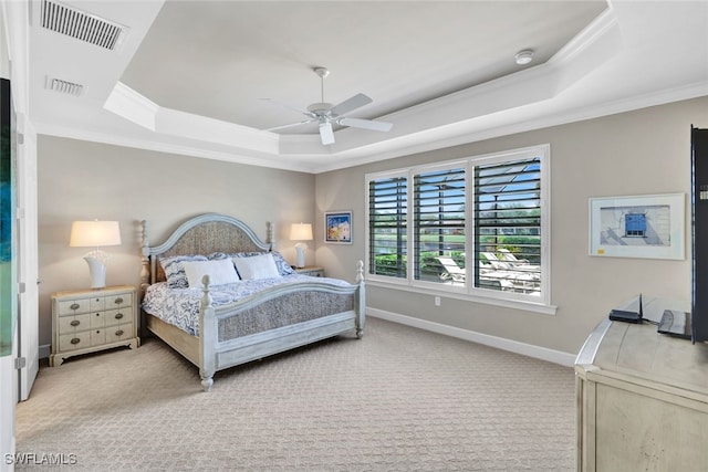 carpeted bedroom featuring ornamental molding, a tray ceiling, and ceiling fan