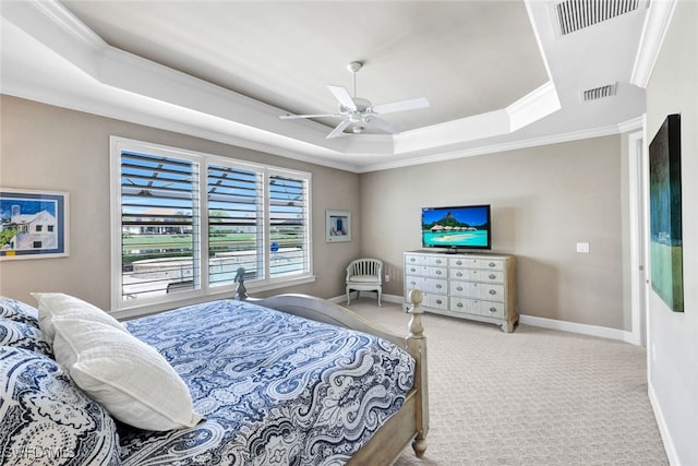 bedroom with ceiling fan, crown molding, light carpet, and a raised ceiling