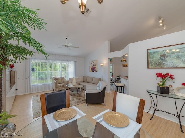 dining area featuring ceiling fan, lofted ceiling, and light hardwood / wood-style flooring