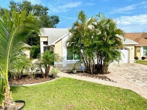 view of front of home featuring a front lawn and a garage