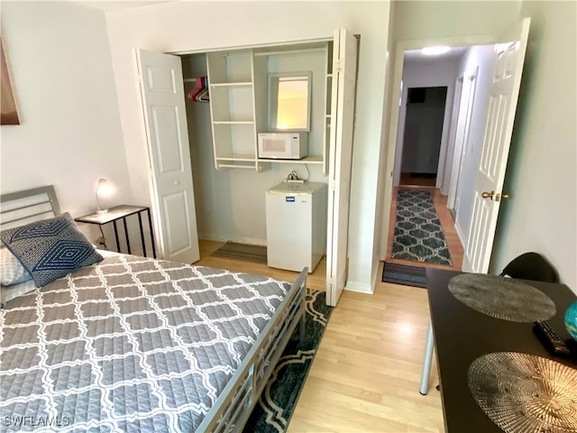 bedroom featuring light wood-type flooring and a closet