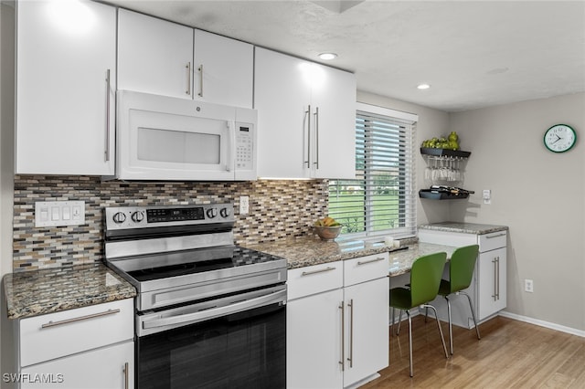 kitchen featuring stainless steel range with electric stovetop, white cabinets, and light hardwood / wood-style flooring