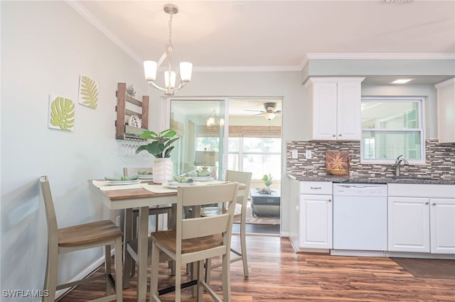 dining area featuring ceiling fan with notable chandelier, crown molding, sink, and dark hardwood / wood-style floors