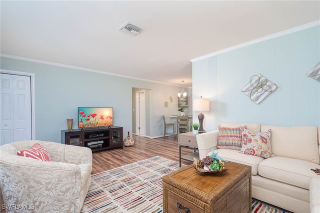 living room featuring an inviting chandelier, ornamental molding, and wood-type flooring