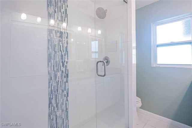 bathroom with plenty of natural light, tile patterned floors, toilet, and walk in shower