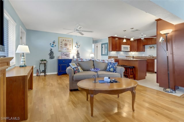 living room featuring ceiling fan and light wood-type flooring