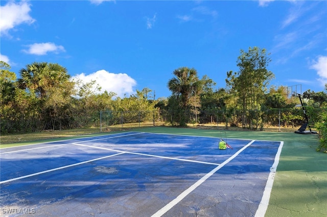 view of tennis court featuring fence