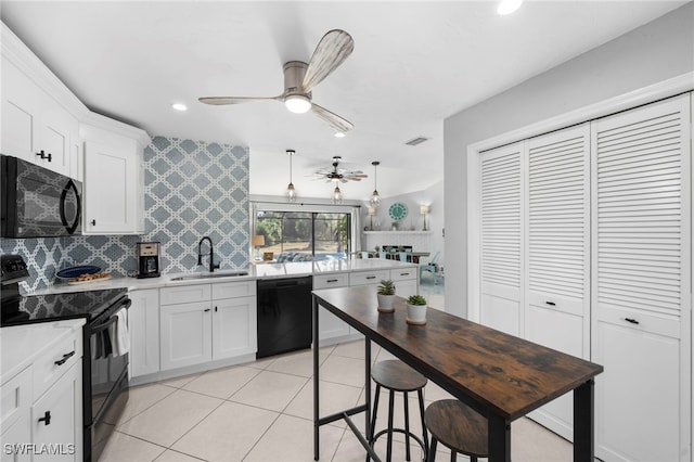 kitchen with a sink, a ceiling fan, white cabinetry, backsplash, and black appliances