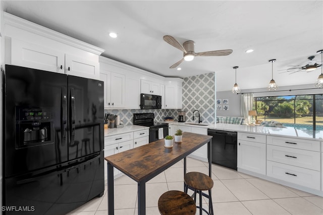 kitchen with a ceiling fan, a sink, white cabinets, black appliances, and a peninsula