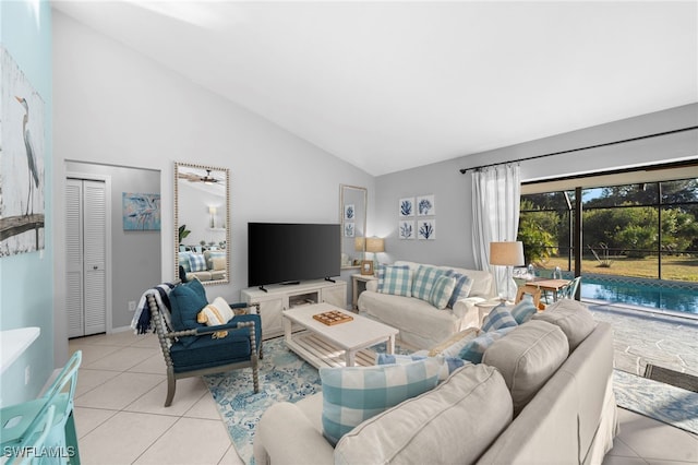 living room featuring ceiling fan, light tile patterned floors, and lofted ceiling