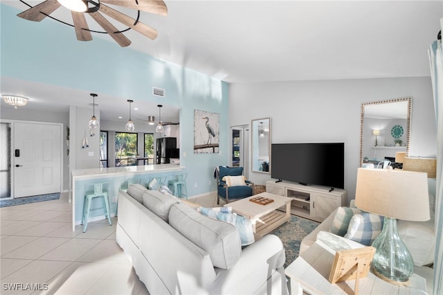 living area with ceiling fan, vaulted ceiling, light tile patterned flooring, and visible vents