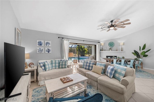 living room featuring baseboards, a ceiling fan, and light tile patterned floors