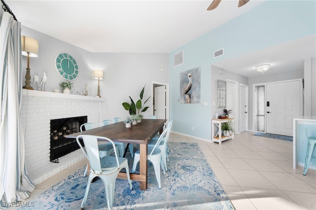 dining space with a fireplace, ceiling fan, and light tile patterned flooring