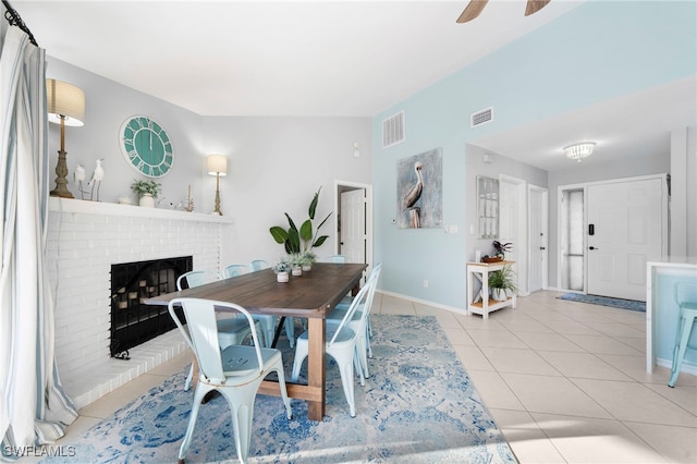 dining space featuring light tile patterned floors, baseboards, a fireplace, and visible vents