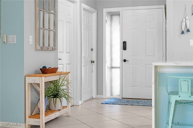entrance foyer with light tile patterned floors and baseboards