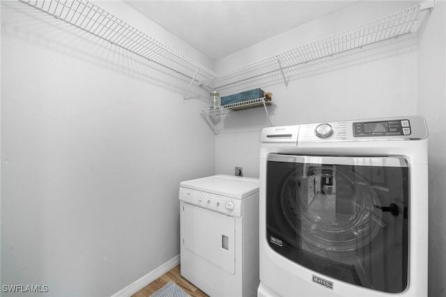 clothes washing area featuring light wood-type flooring and independent washer and dryer