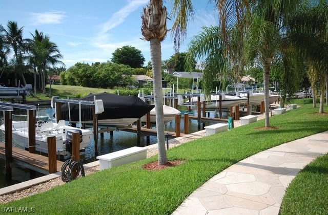 dock area featuring a lawn and a water view