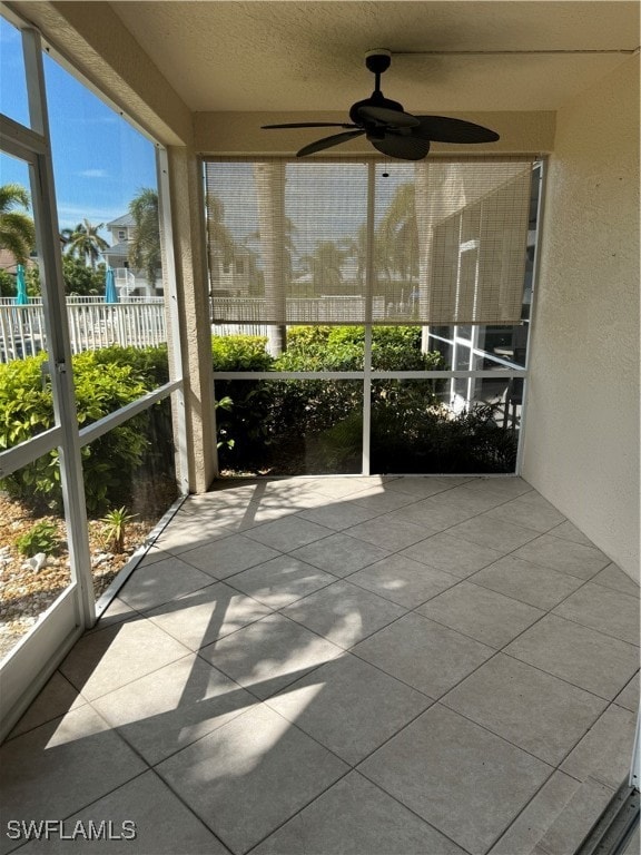 unfurnished sunroom with a wealth of natural light and ceiling fan