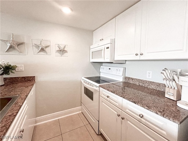 kitchen with white appliances, light tile patterned flooring, white cabinetry, and baseboards