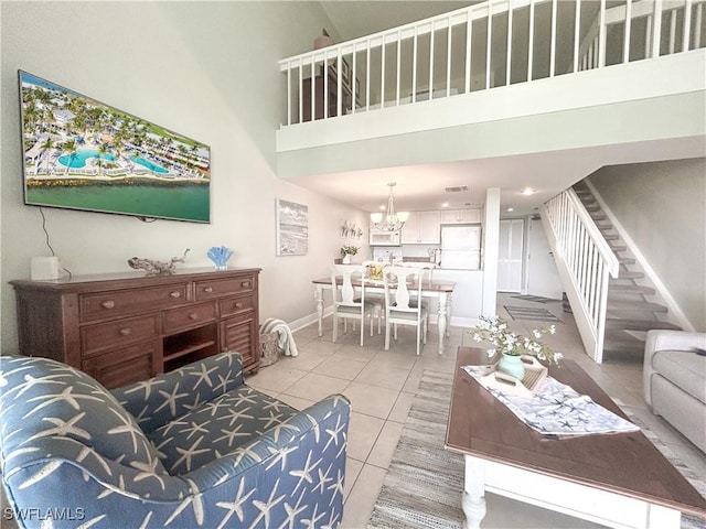 living area featuring light tile patterned floors, visible vents, stairway, a high ceiling, and baseboards