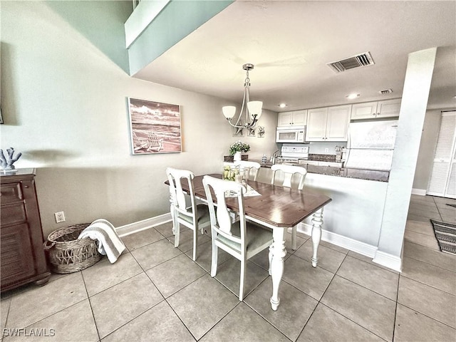 dining space featuring a chandelier, visible vents, baseboards, and light tile patterned flooring