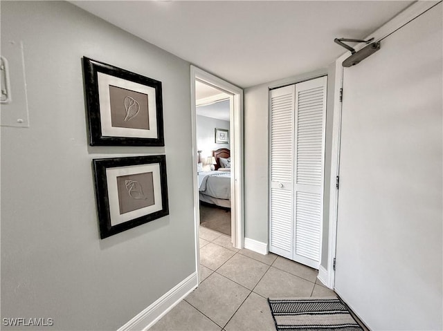 hall with light tile patterned floors and baseboards