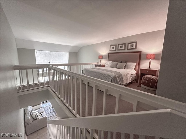 bedroom featuring lofted ceiling and tile patterned flooring