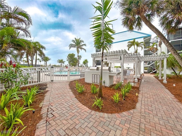 view of community featuring a patio area, fence, a pool, and a pergola