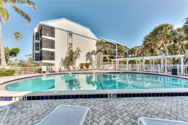 community pool featuring fence and a patio