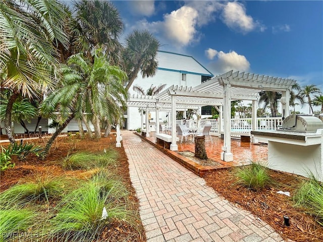 view of property's community featuring a patio, a pergola, and area for grilling