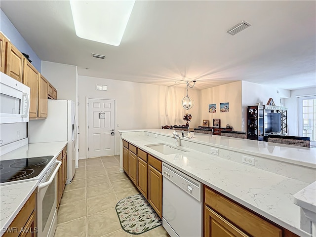 kitchen featuring hanging light fixtures, light tile patterned floors, light stone countertops, sink, and white appliances