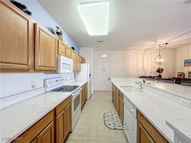 kitchen featuring hanging light fixtures, light tile patterned floors, a chandelier, sink, and white appliances