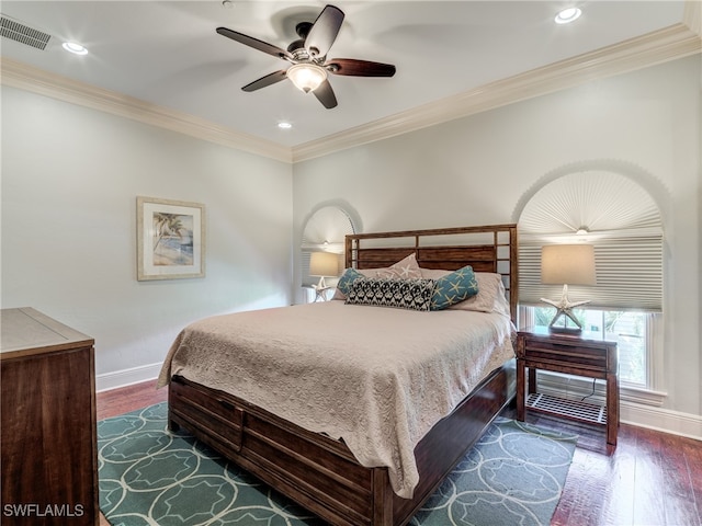 bedroom with dark wood-type flooring, crown molding, and ceiling fan