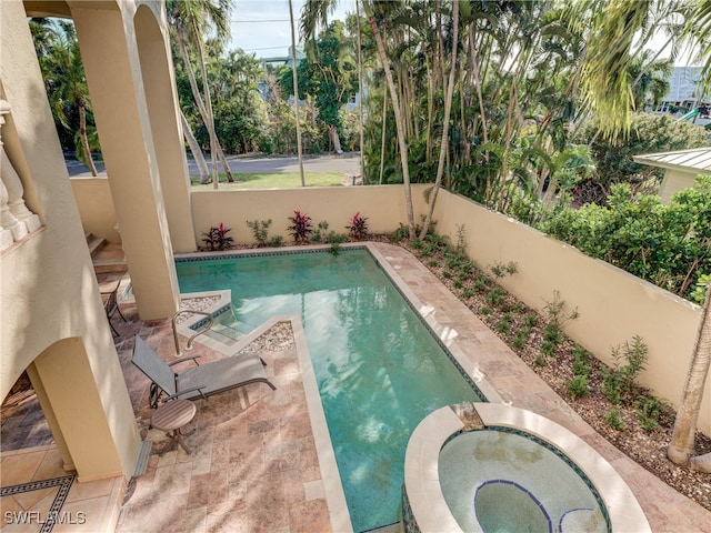 view of swimming pool featuring a patio and an in ground hot tub