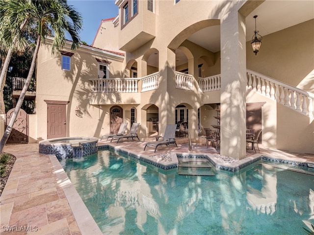 view of pool with an in ground hot tub and a patio area