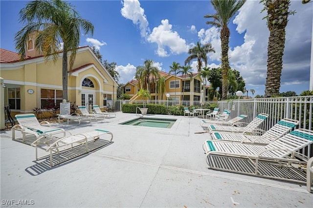 view of swimming pool featuring a patio and a hot tub