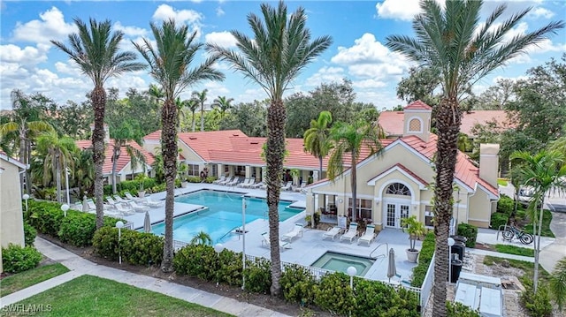 view of swimming pool featuring a patio and a hot tub