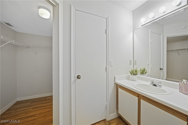 bathroom featuring vanity, hardwood / wood-style floors, and a textured ceiling