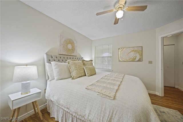 bedroom featuring ceiling fan, a textured ceiling, and dark hardwood / wood-style floors